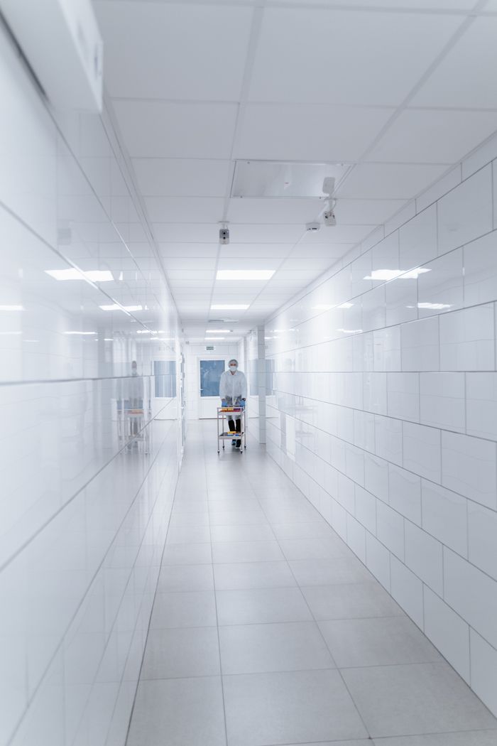 Scientist in a sterile, bright laboratory hallway, showcasing modern medical technology.