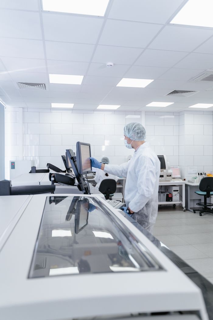 A scientist in protective gear conducting research in a modern laboratory environment.